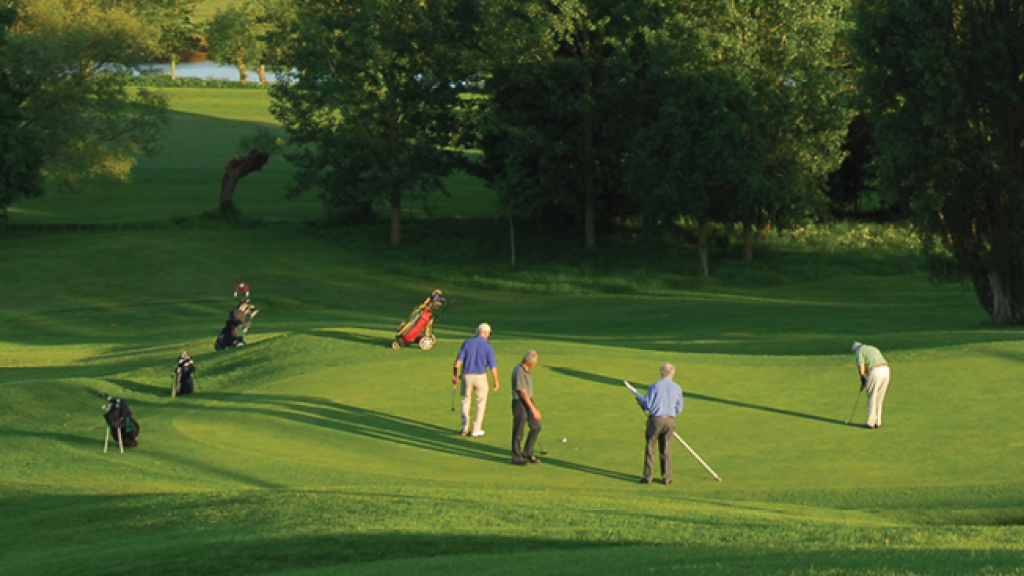 Golfers on golf course green 